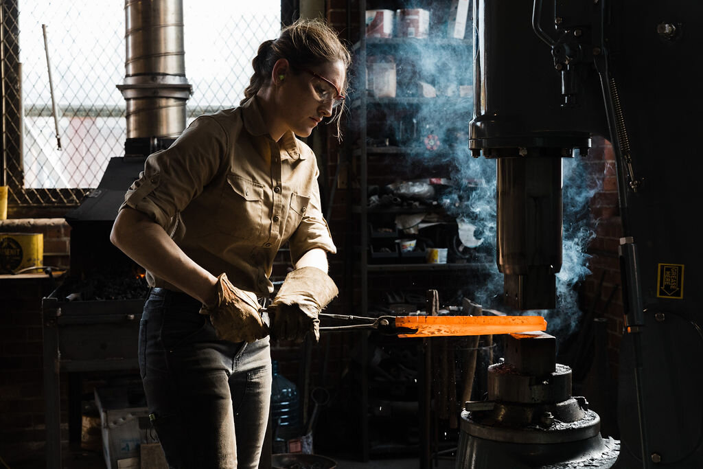 Alaina Mahoney, a welder, working with a power hammer.